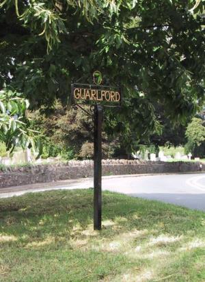 The village sign, designed by the Clerk and made by Mr D Morgan, the Barnard's Green blacksmith.